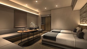 A modern hotel room with a sofa, a small table with a vase, and a bed with pillows. - Minn Kyoto Shijo (Kyoto)