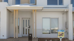 A modern building with a white facade, a covered entrance, and a mailbox. - Cormorant Retreat Family-Friendly Torquay Escape (Torquay)
