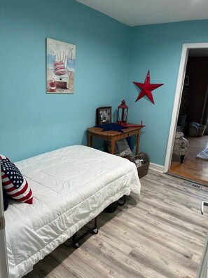 A bedroom with a bed, a star decoration, a small table with a lantern, and a picture on the wall. - Sand Lake Extended Stay Ranch - Fully Furnished Lake Home - Monthly Stays (Lindenhurst)