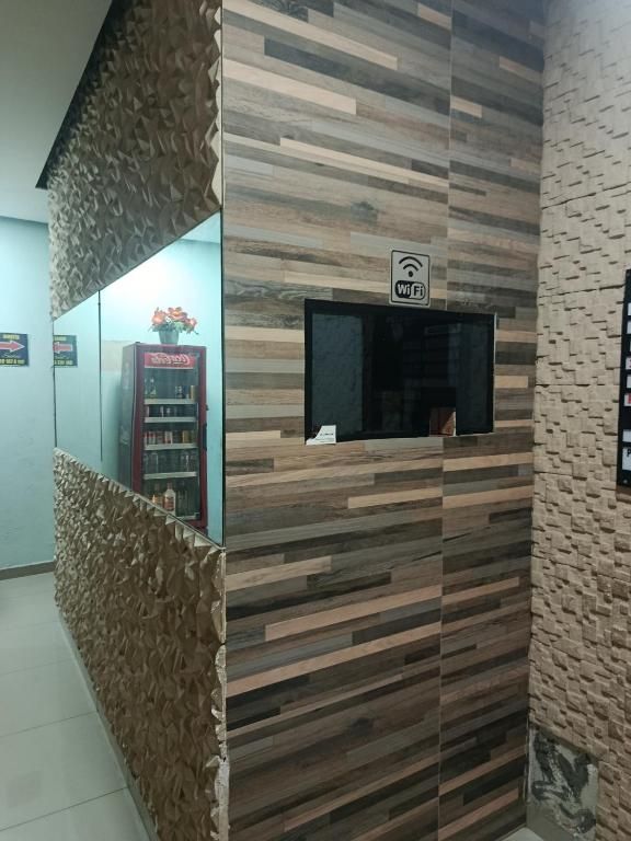 Un espace d’accueil avec un mur recouvert de panneaux en bois, un panneau indiquant la présence d’une connexion Wi-Fi et un comptoir agrémenté d’un objet décoratif.