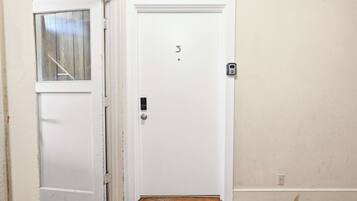 A white door with a number '3' on it, a keypad lock, and a small window above the door.