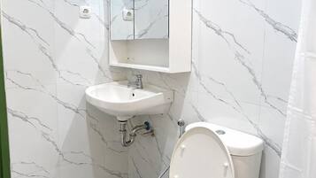 Ein modernes Badezimmer mit Toilette, Waschbecken und Spiegel.