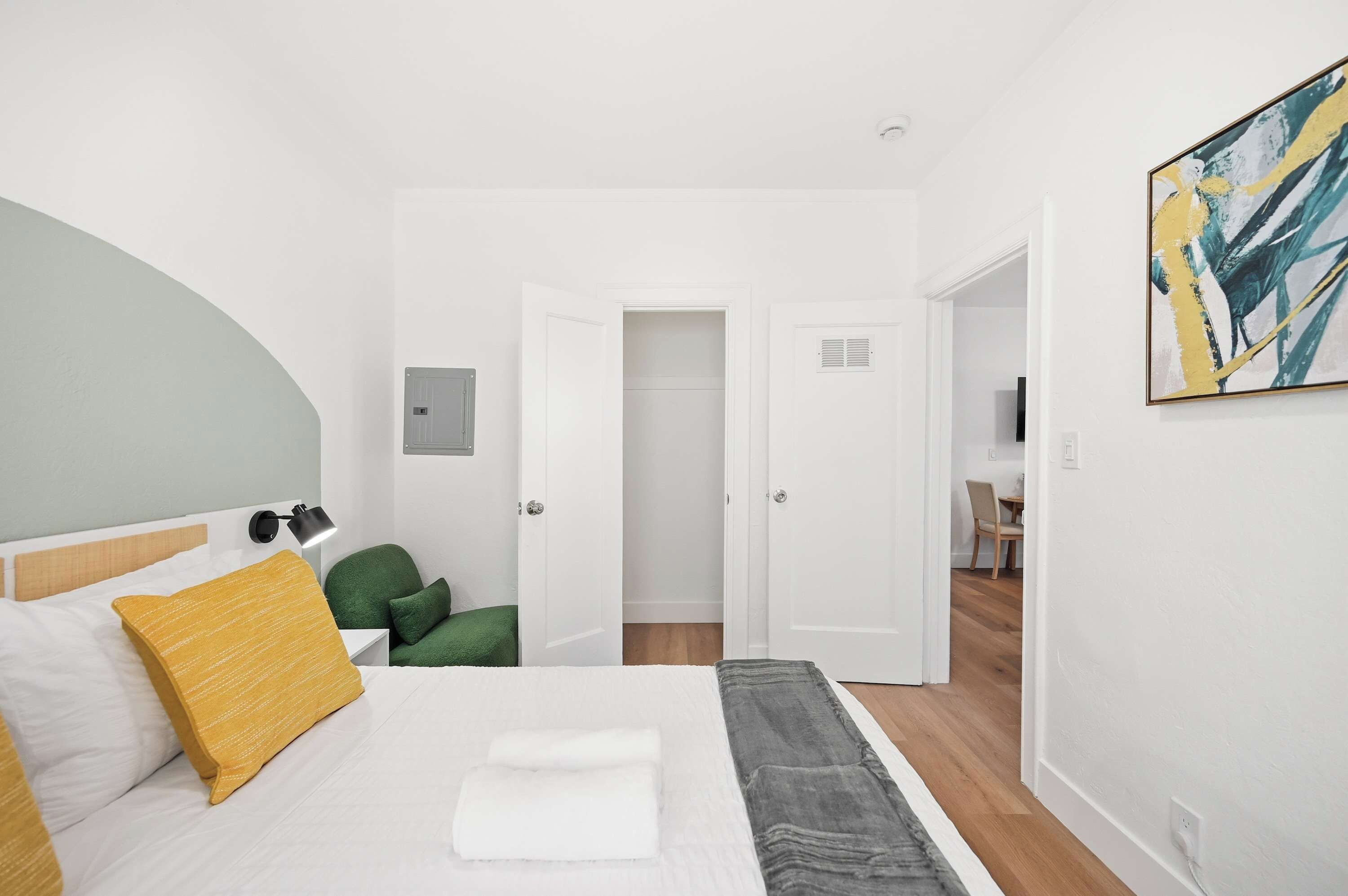 A hotel room with a bed, a desk, and a chair.