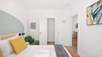 A hotel room with a bed, a desk, and a chair.