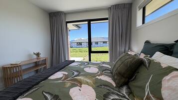 Une chambre à coucher avec un lit, une petite table et une fenêtre donnant sur les montagnes.