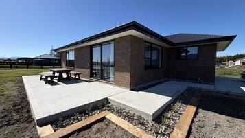 Un bâtiment moderne doté d’un patio, d’un espace extérieur aménagé pour s’asseoir et offrant une vue sur le paysage environnant.