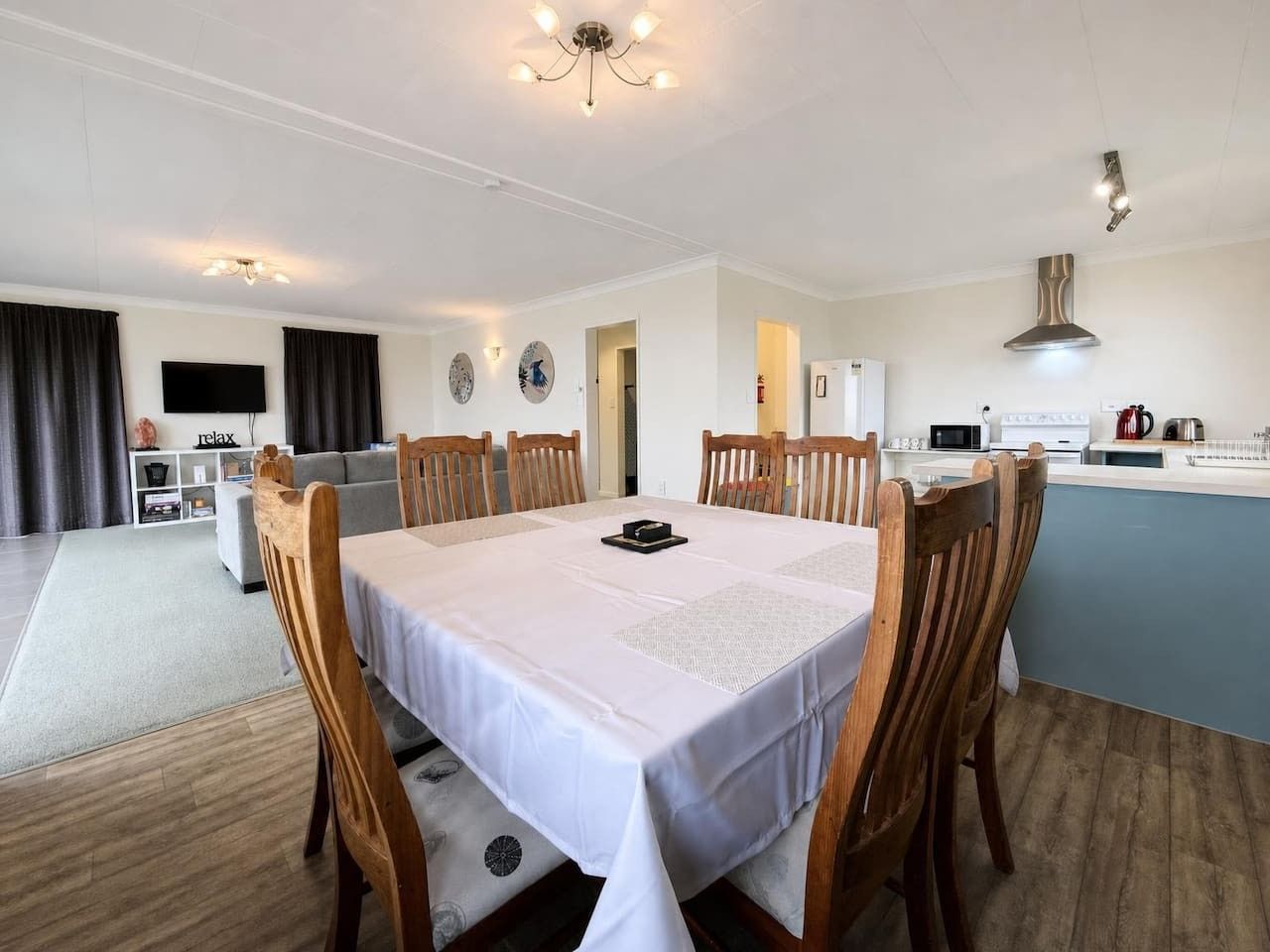 A dining area with a table set for six, surrounded by wooden chairs.