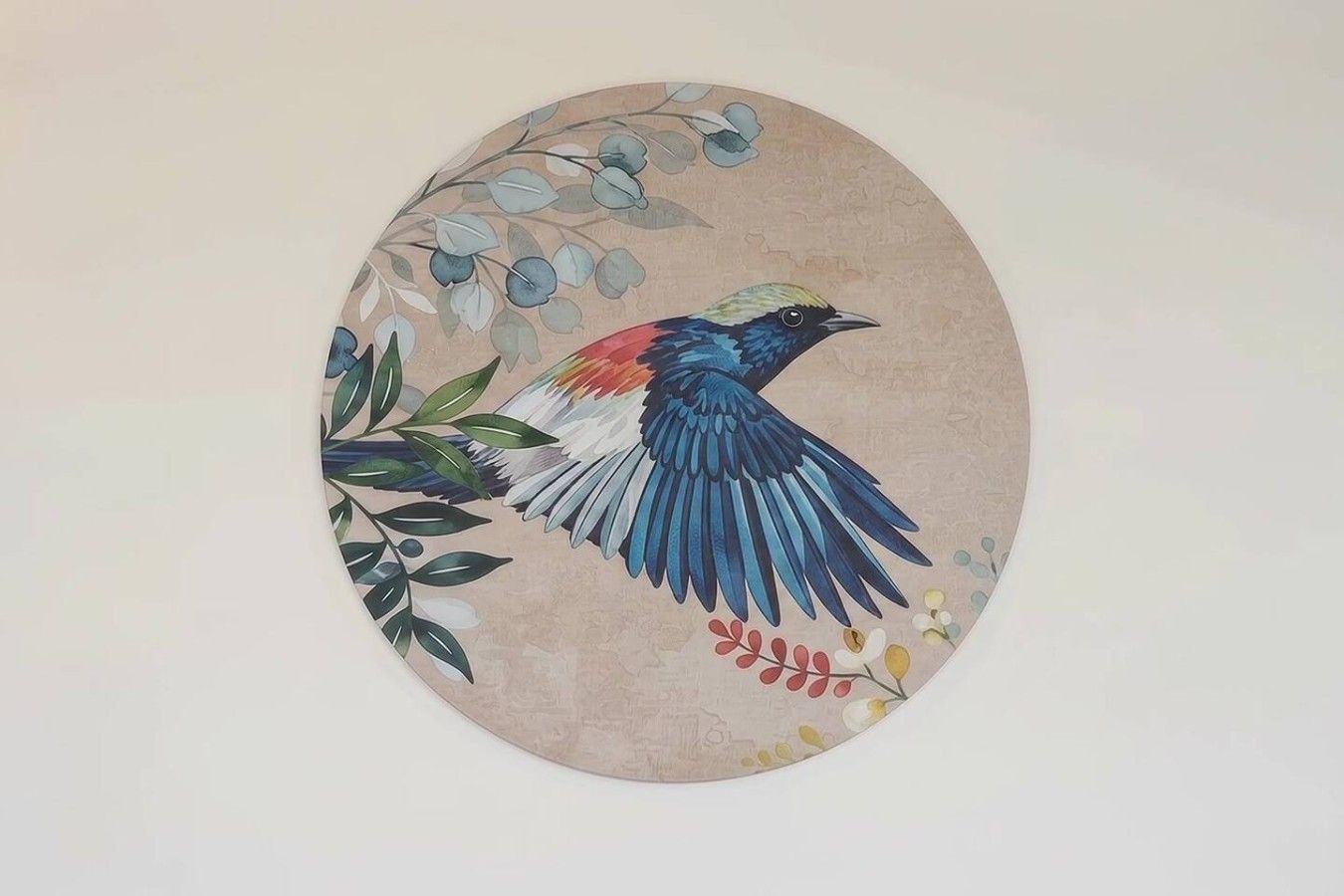 Una obra de arte circular con un pájaro y follaje.