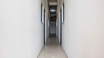 A corridor with doors on both sides, leading to an interior space.