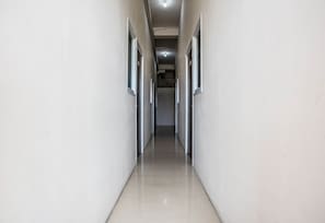 Un pasillo con puertas a ambos lados, que conduce a un espacio interior.