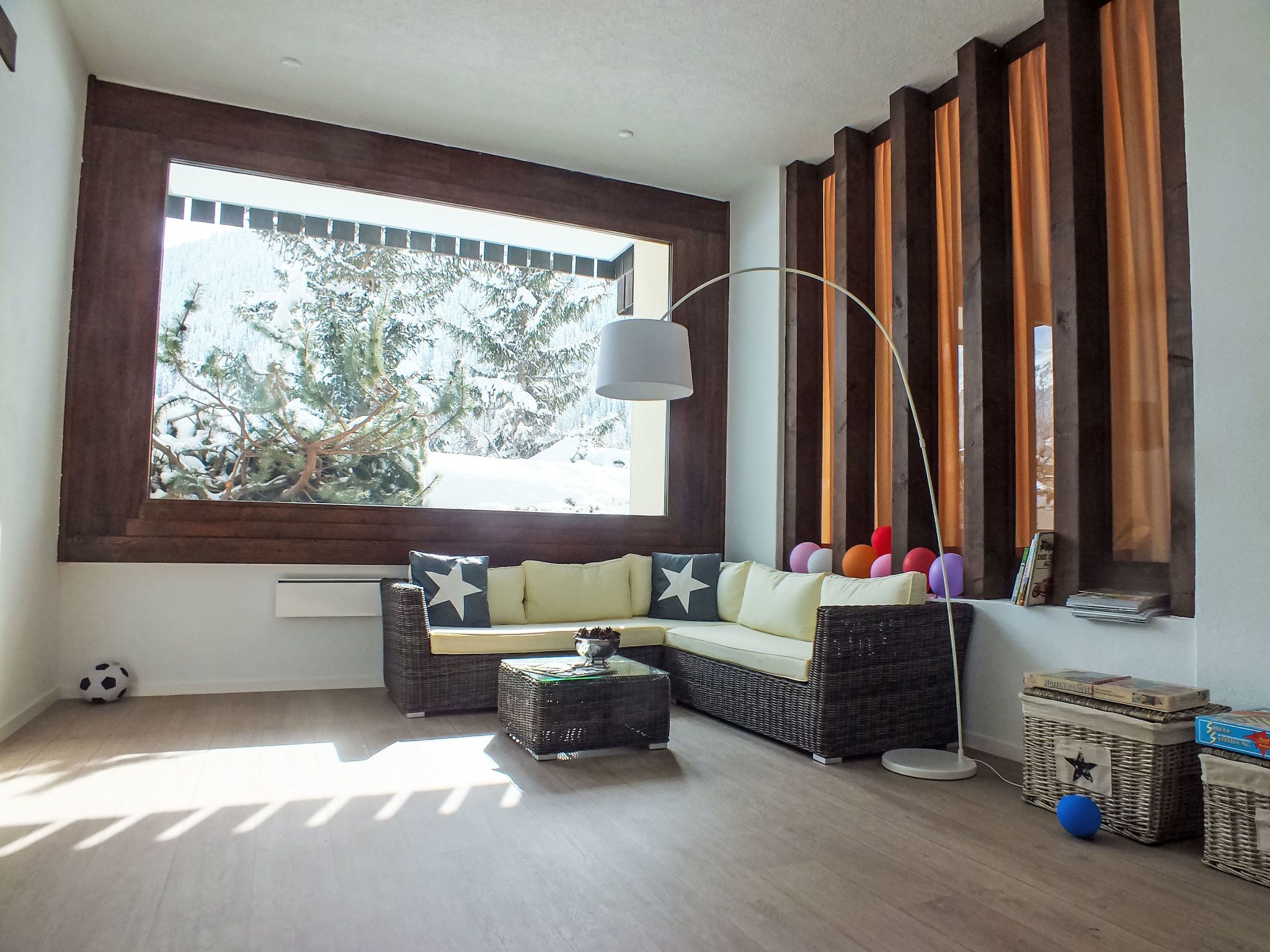 Una sala de estar con un ventanal grande, un sofá, una mesa de centro y una lámpara.