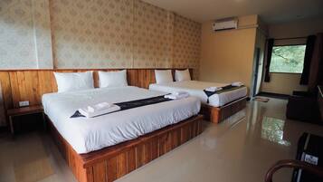 A hotel room with two beds, a wooden headboard, a nightstand, and a window with curtains.