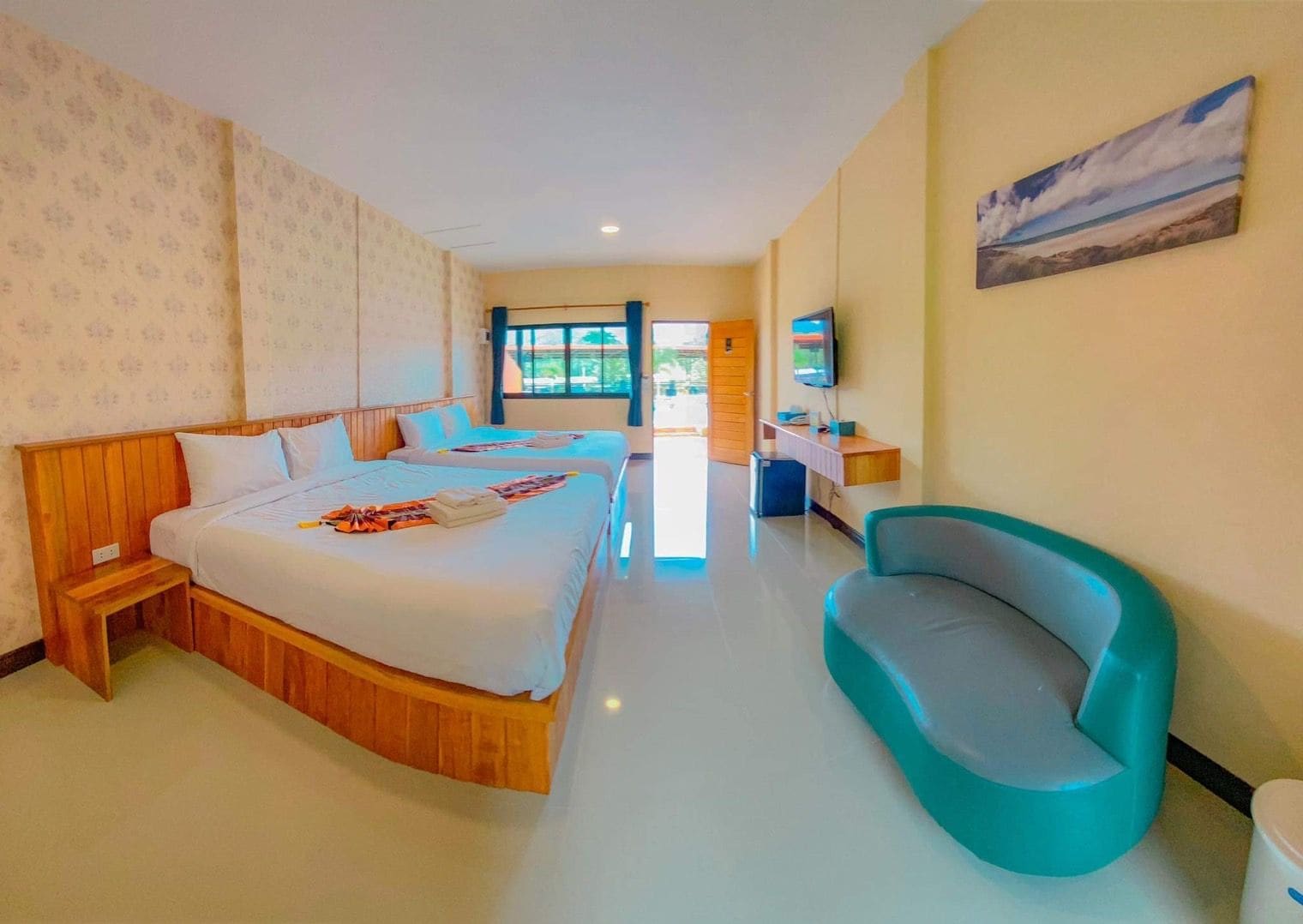 A hotel room with two beds, a television, a desk, and a chair.