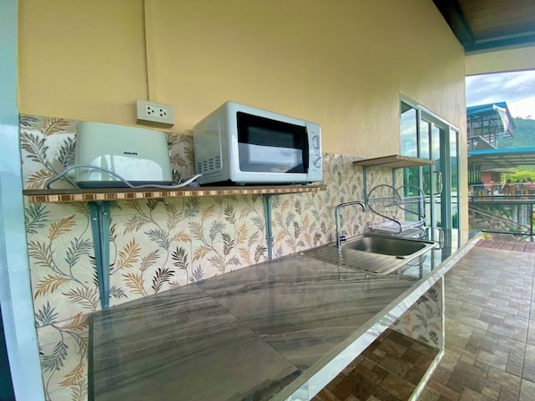 A kitchen with a microwave, a sink, and a power outlet.
