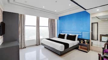 Habitación de hotel moderna con una cama grande, una mesita de noche, un espejo y vistas a la ciudad a través de la ventana.