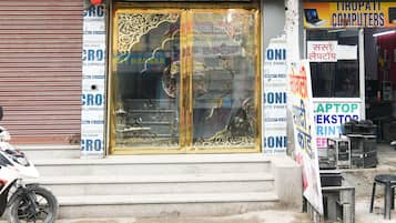 Un escaparate con un amplio escaparate de vidrio, varios carteles y una motocicleta estacionada afuera.