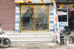 Un escaparate con un amplio escaparate de vidrio, varios carteles y una motocicleta estacionada afuera.