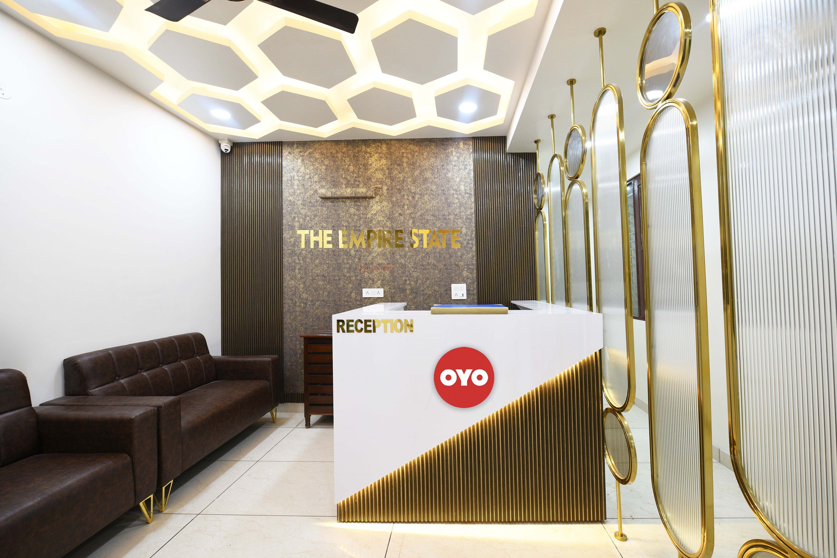 A reception area with a reception desk, a sofa, and a wall with the text 'THE EMPIRE STATE'.