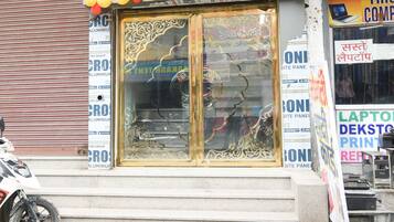 A storefront with a large glass door, surrounded by various advertisements.