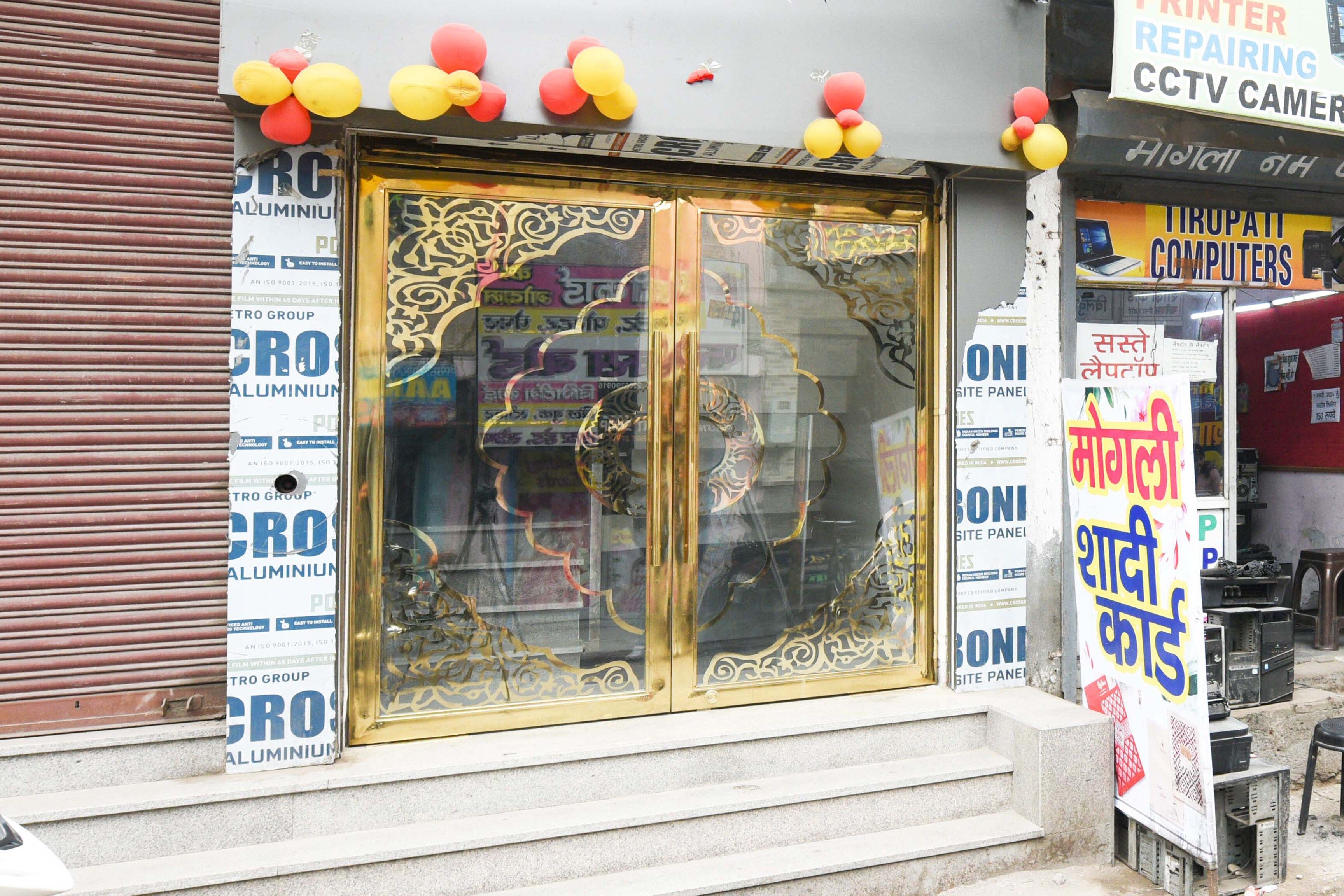 Un escaparate con una puerta de cristal grande que presenta diseños intrincados, rodeado de varios letreros y anuncios.