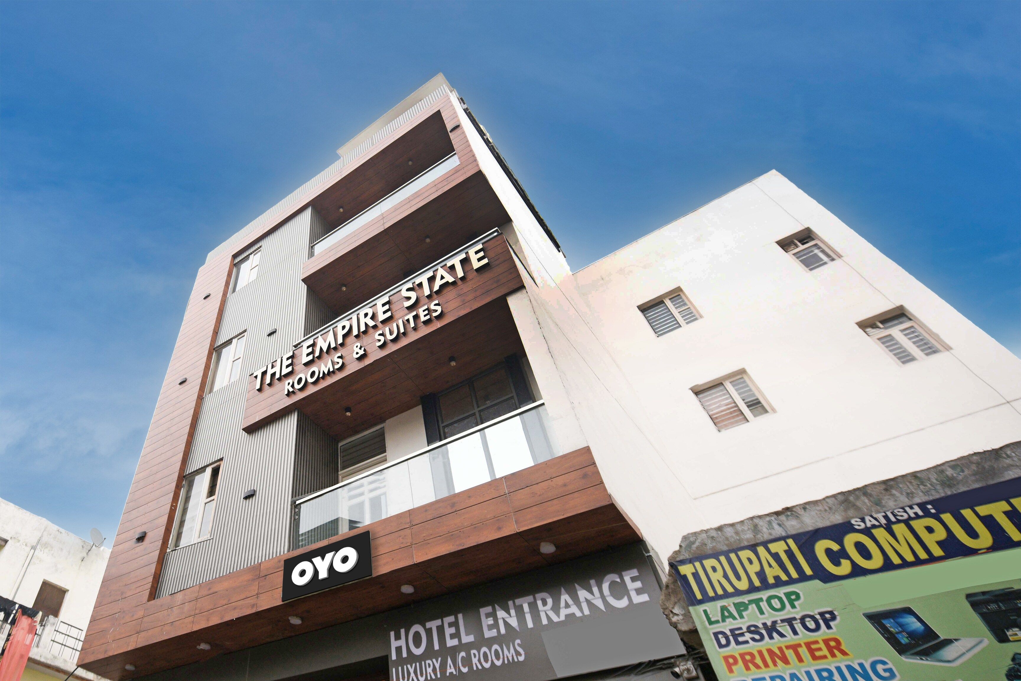 A hotel named 'The Empire State Suites' with a sign for 'Hotel Entrance' and a sign for 'Oyo' on the building.