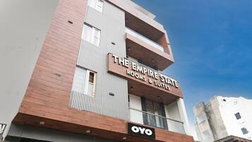 Un edificio de varios pisos con un letrero que dice 'The Empire State Rooms & Suites' y la marca 'OYO'.