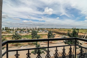 Un balcó amb vista a una zona residencial, incloent cases i terrenys oberts.