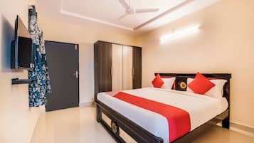 Une chambre d’hôtel avec un lit, une armoire et un ventilateur de plafond.