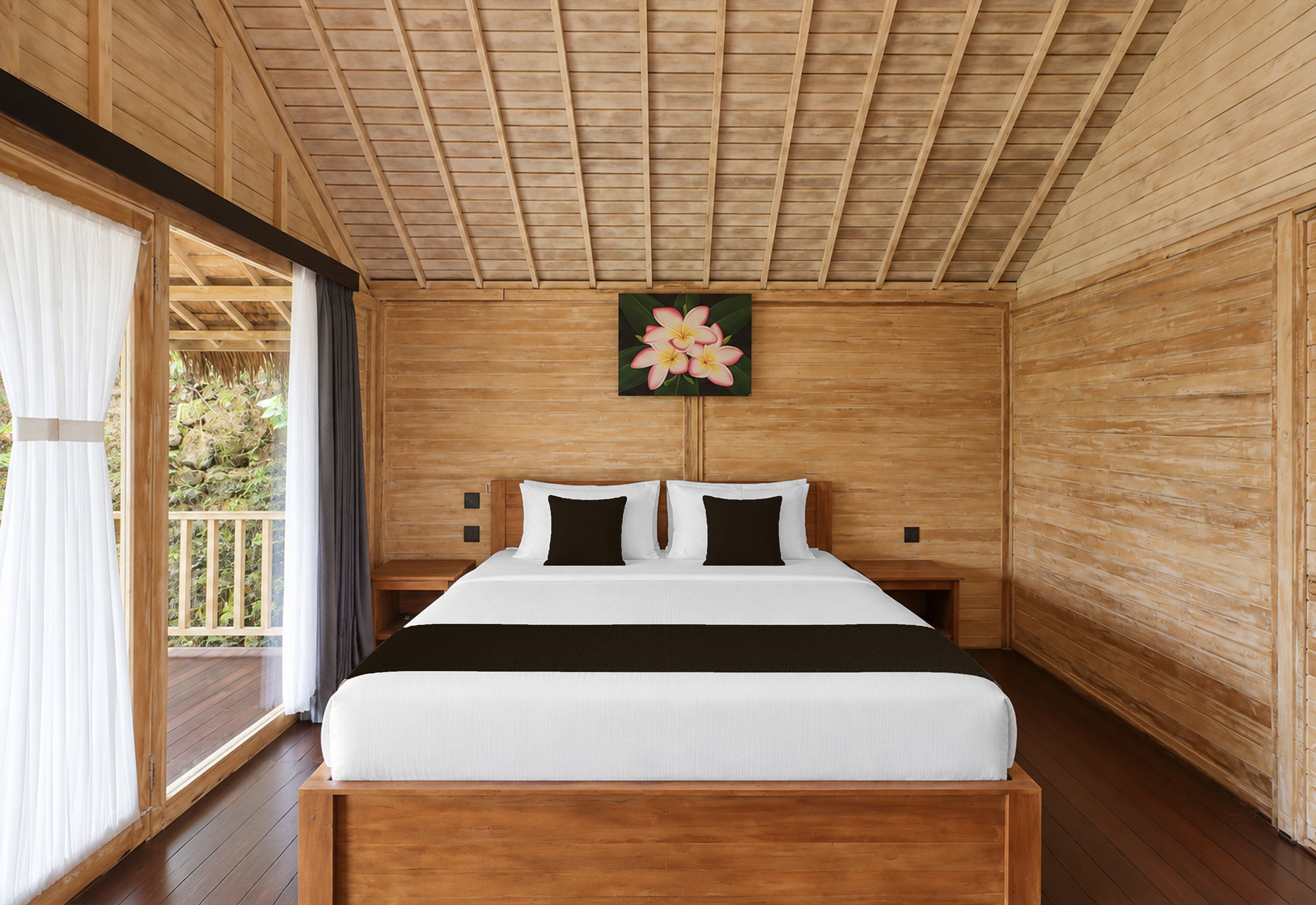 Quarto de madeira com uma cama, um quadro e vista pela janela.
