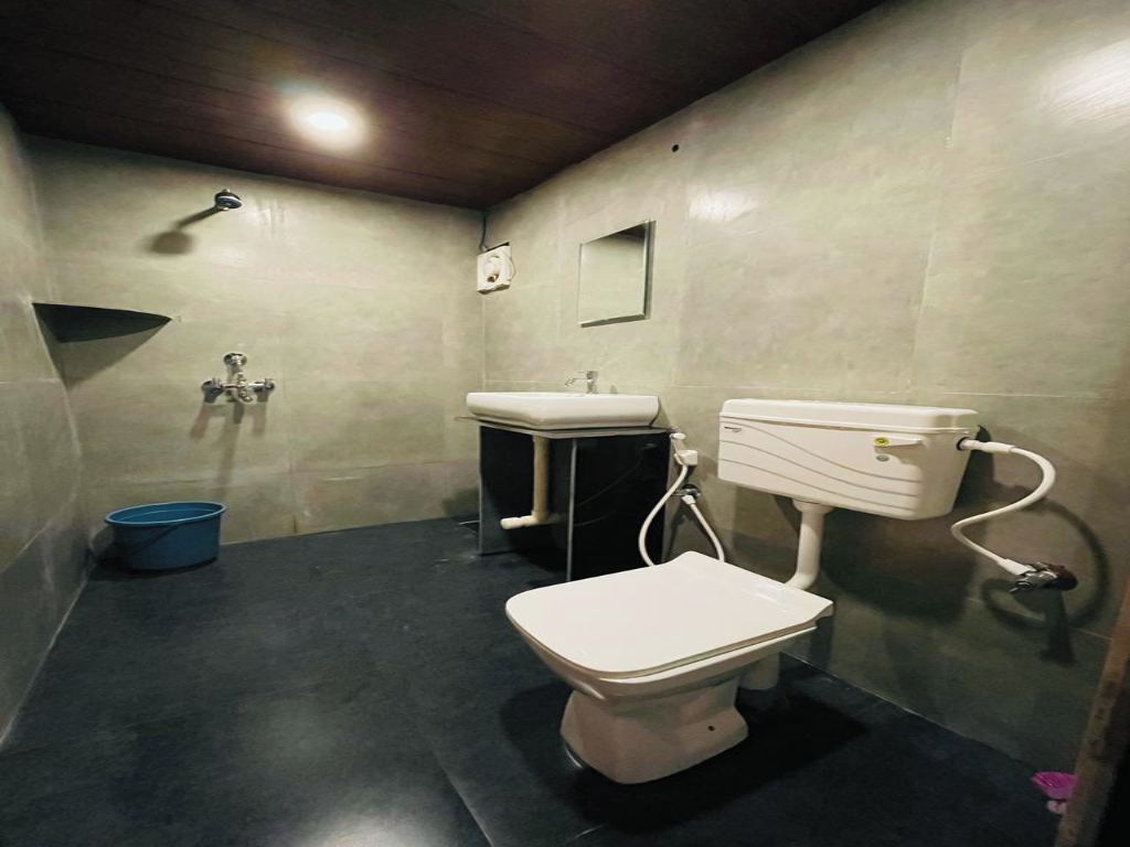 Un baño pequeño y cerrado con inodoro, lavabo y ducha.
