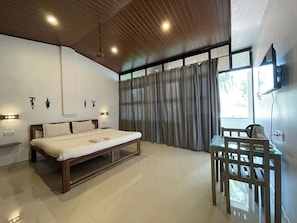 Un dormitorio moderno con cama, mesitas de noche, escritorio y televisor.