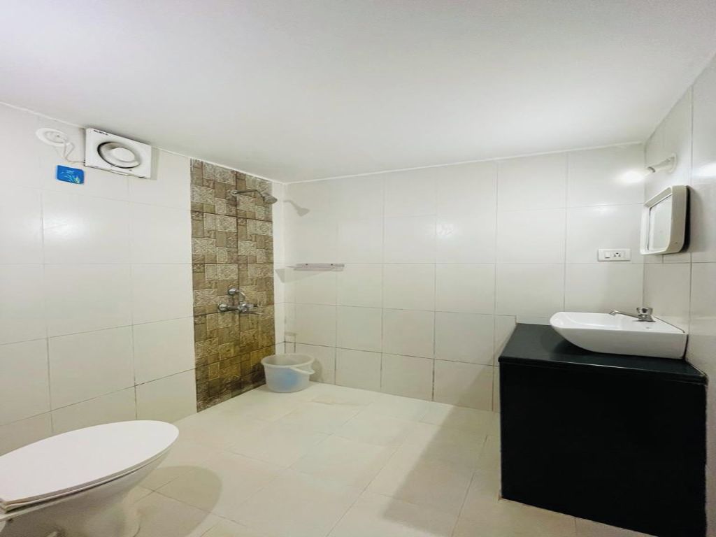 Une salle de bain comprenant des toilettes, un lavabo et un espace douche.
