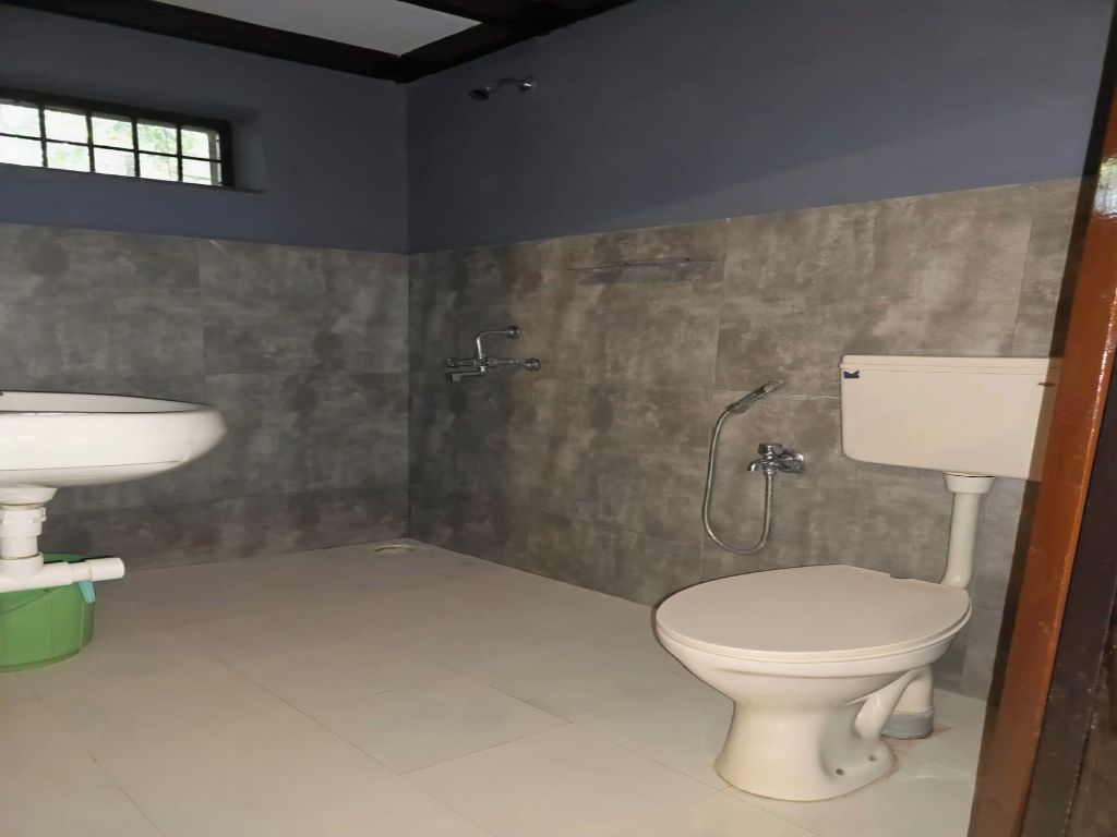 Une salle de bain avec des toilettes, un lavabo et une douche.