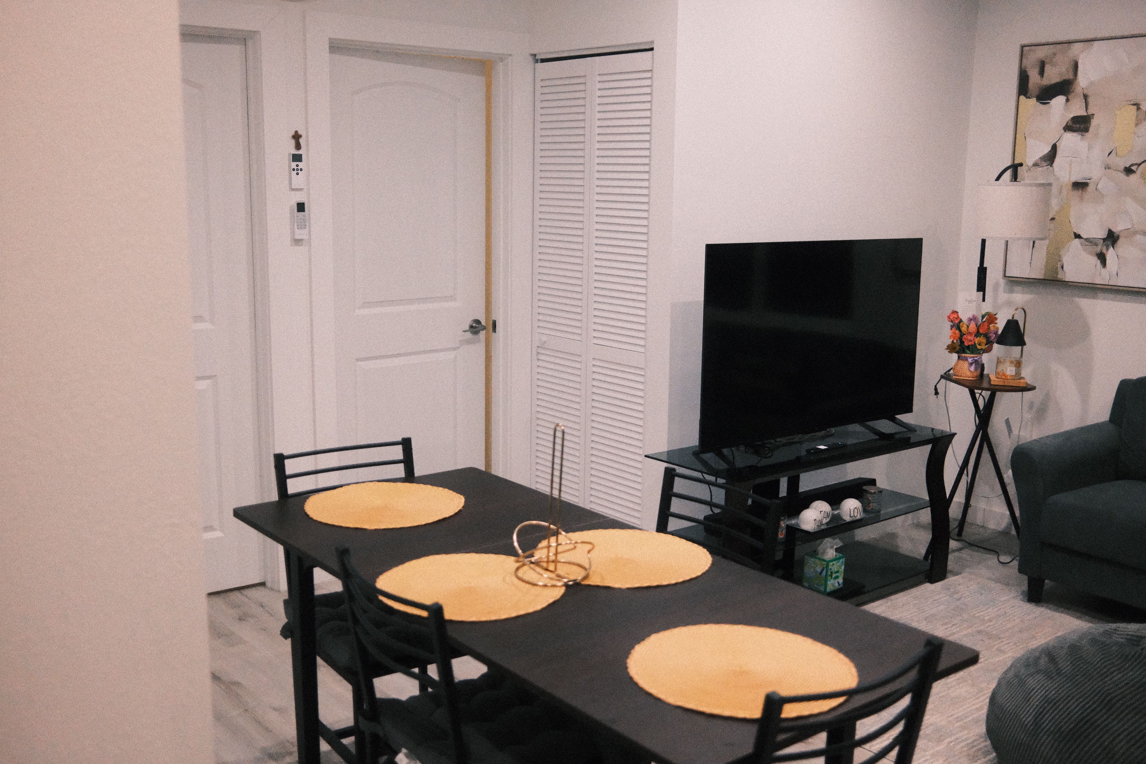 Un comedor con una mesa, sillas, un televisor y un sofá.