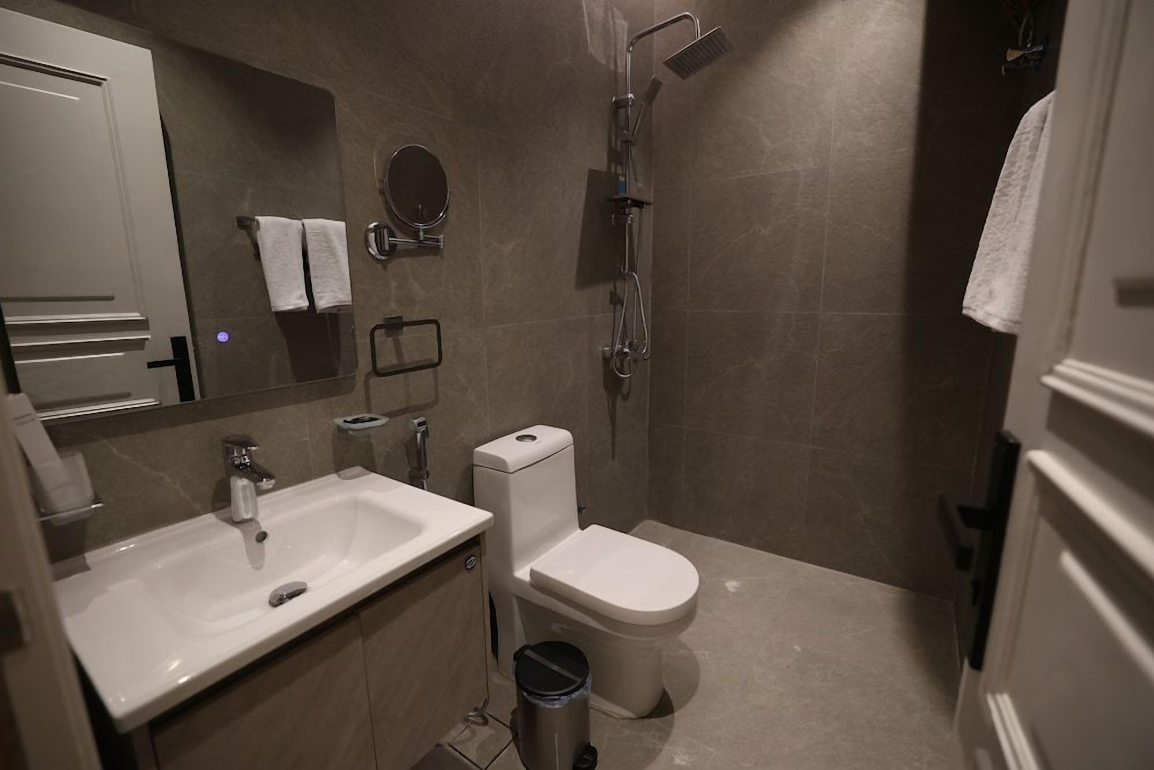 A modern bathroom with a sink, toilet, and shower.