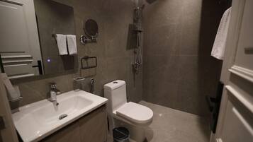 A modern bathroom with a sink, toilet, and shower.