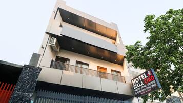 A modern hotel with a signboard indicating 'HOTEL BELL Ciao' and contact details.