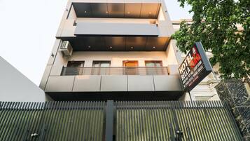 A multi-story hotel with a modern design, featuring balconies and a prominent sign advertising luxury rooms.