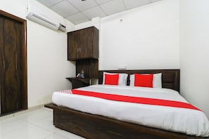 A hotel room with a wooden bed, white bedding, and red accents. - Hotel O Rk Inn (Ludhiana)