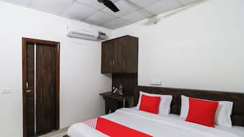 Un dormitorio con cama, armario, escritorio y ventilador de techo.