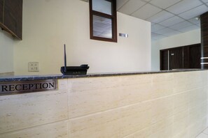 A reception desk with a sign labeled 'RECEPTION' and a wall-mounted intercom.