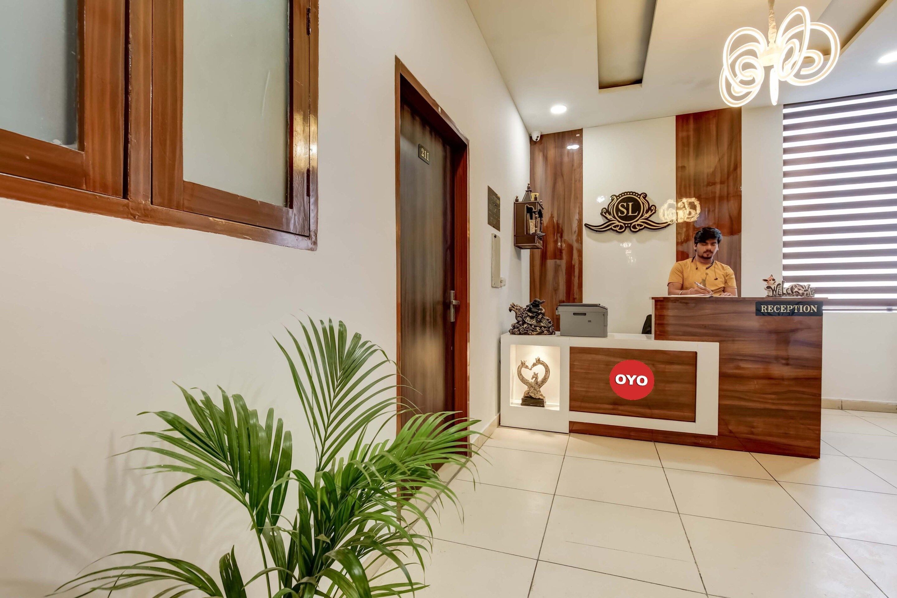 A reception desk with a 'RECEPTION' sign, a 'SL' logo, and a 'OYO' logo.