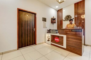Una mesa de recepción con un cartel que dice 'Reception' y un logotipo 'OYO'.