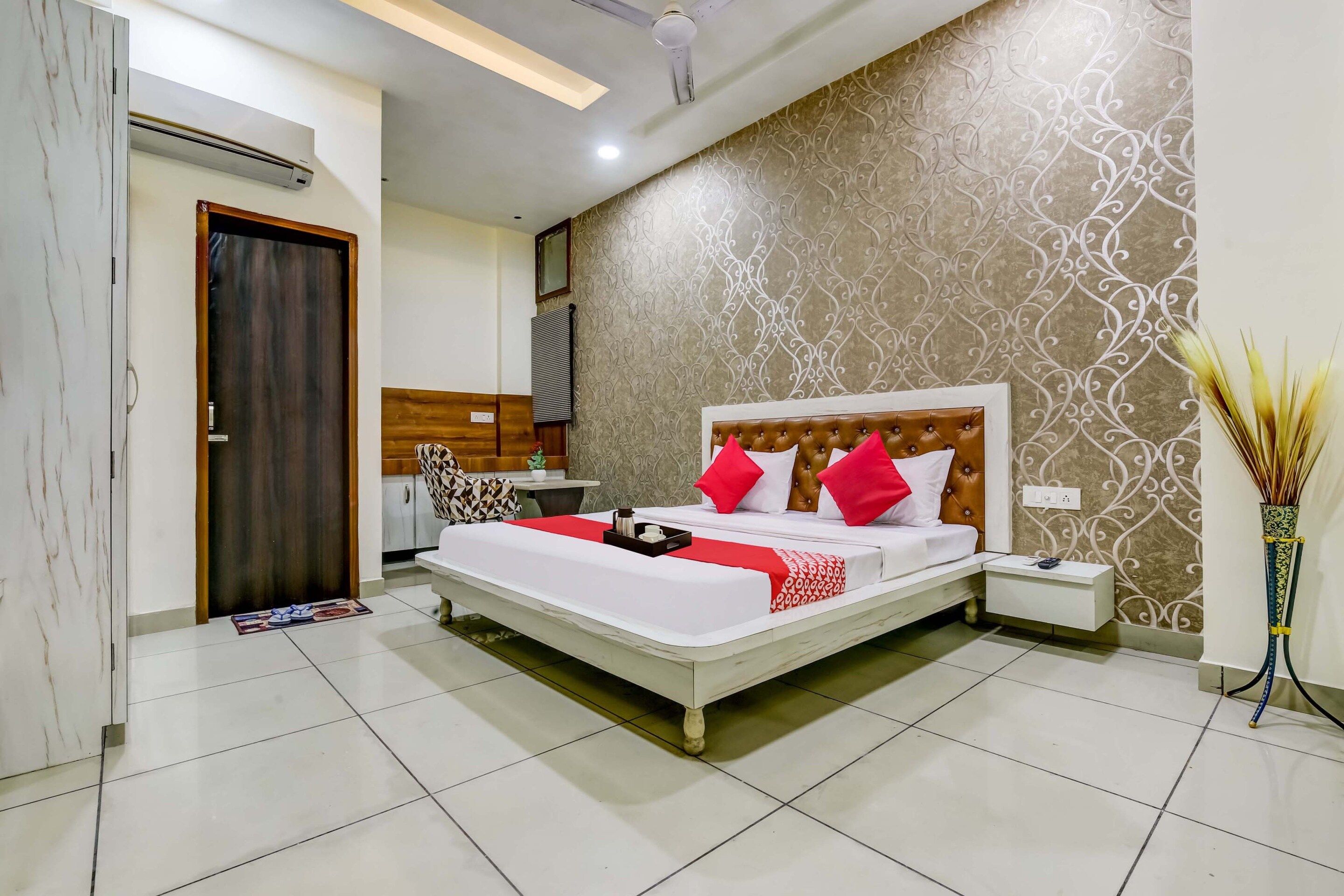 A hotel room with a bed, bedside table, and a decorative wall.