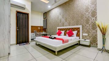 A hotel room with a bed, bedside table, and a decorative wall.