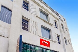 Un edificio con un letrero que indica 'OYO Rooms', alojamiento de hotel.