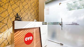 A reception area with a reception desk, a glass door, and a geometric patterned wall.