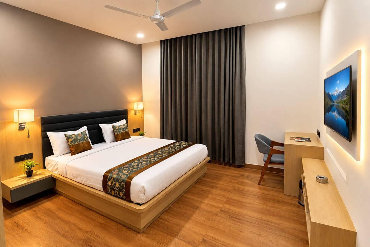 Ein modernes Hotelzimmer mit einem großen Bett, Nachttischlampen, einem Schreibtisch und einem Deckenventilator.