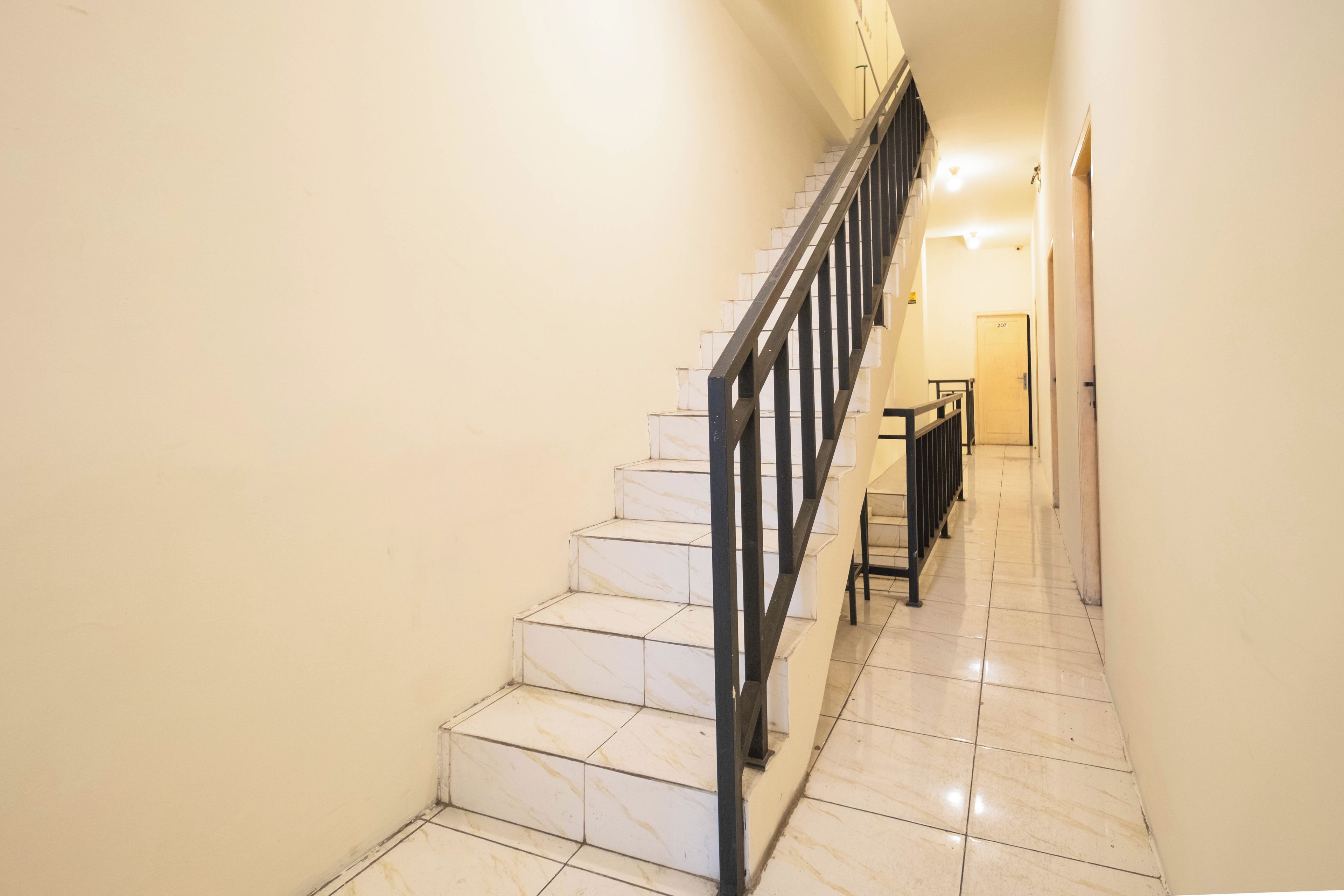 A staircase with a metal railing leading to a landing.
