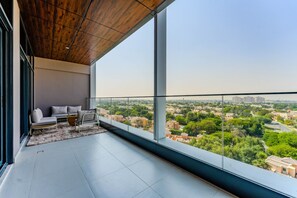 A balcony with a city view, a sofa, and a coffee table. - HAVN - 1 Bed in Vista Prestige, Dubai Sports City (Dubai)